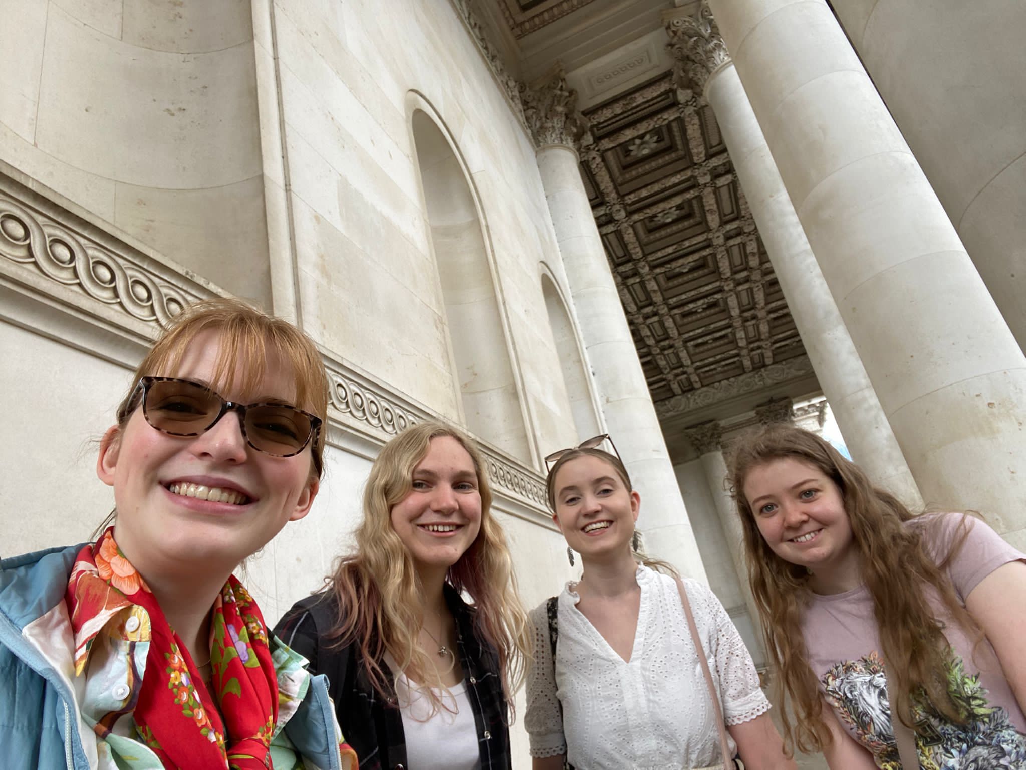 Selfie with four students, next to some pillars and under an ornately decorated ceiling.
