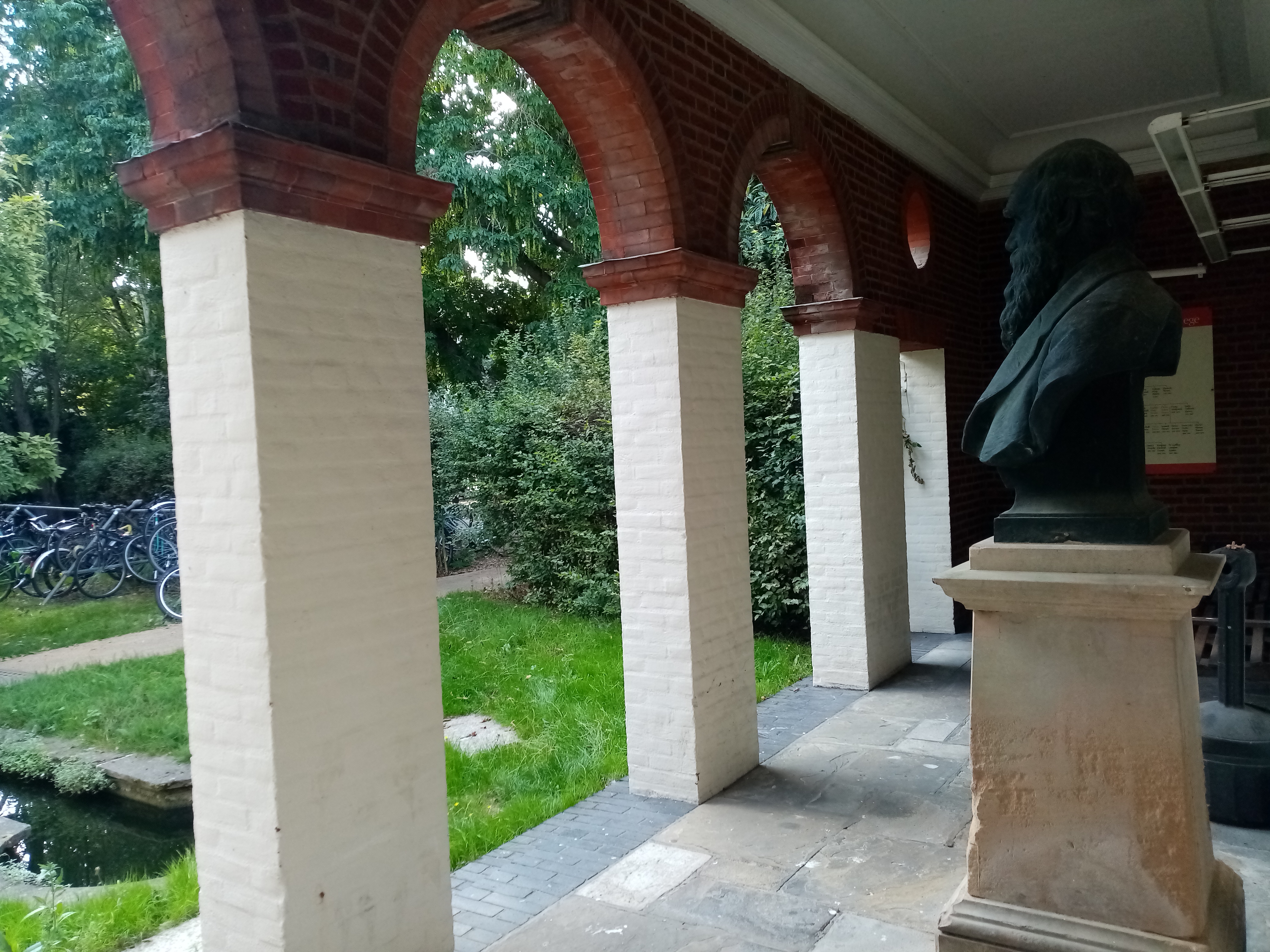 view from the Darwin portico: the back of a bust of Charles Darwin, and some arches that lead to green space