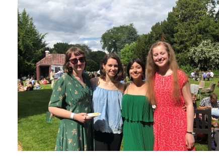 Four female students in summer dresses, posing together, in the Fellows Garden of Christ's College, Cambridge, during the College's annual garden party.
