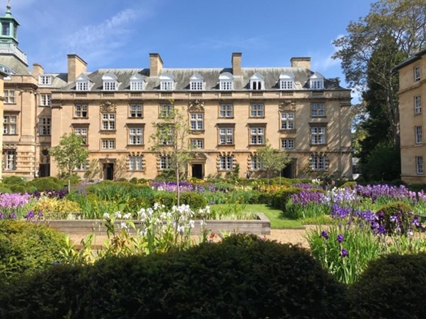 garden with flowerbeds in front of old white building in third court