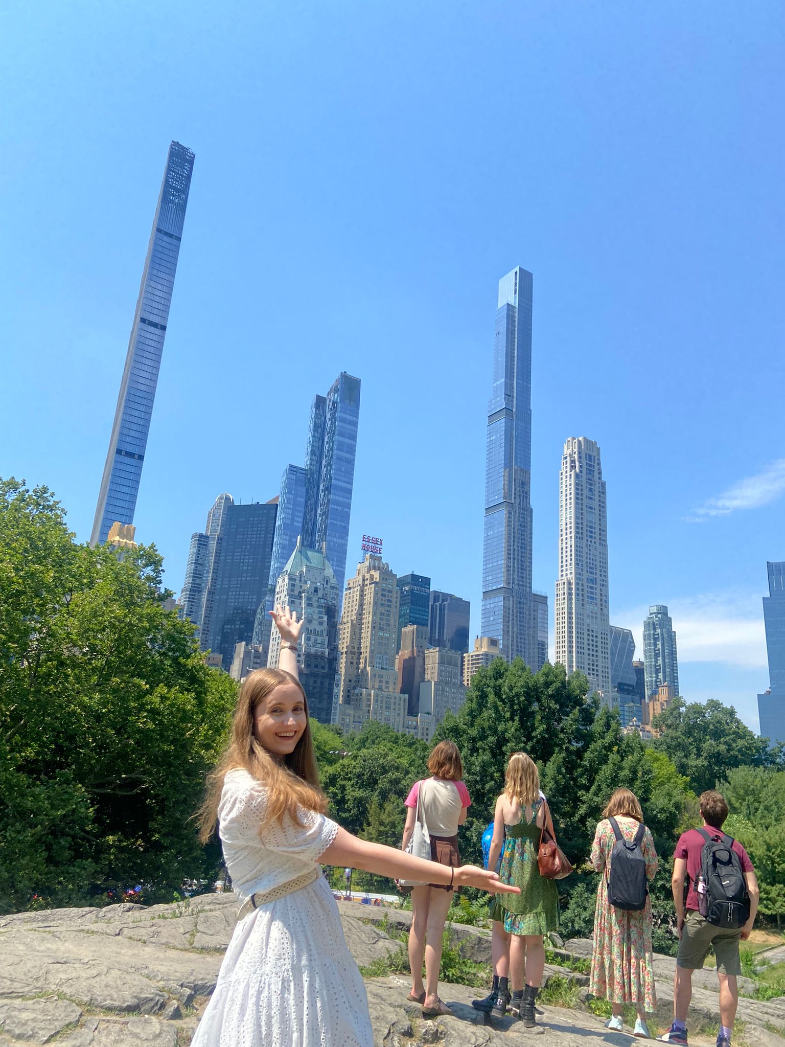 Emily gesturing towards a New York skyline