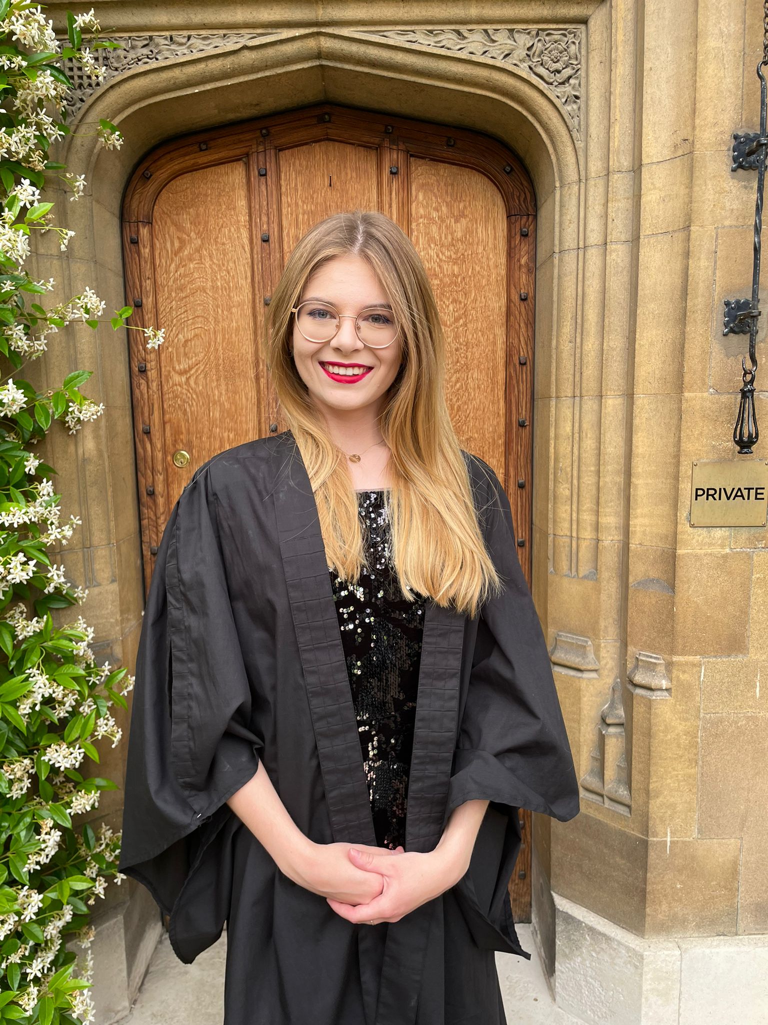 A student stands in front of a wooden doorway