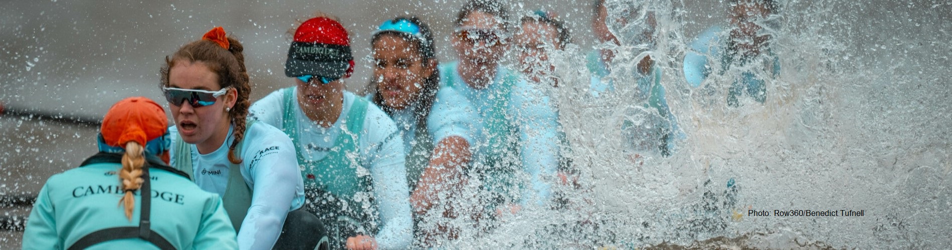 Five people rowing with spray