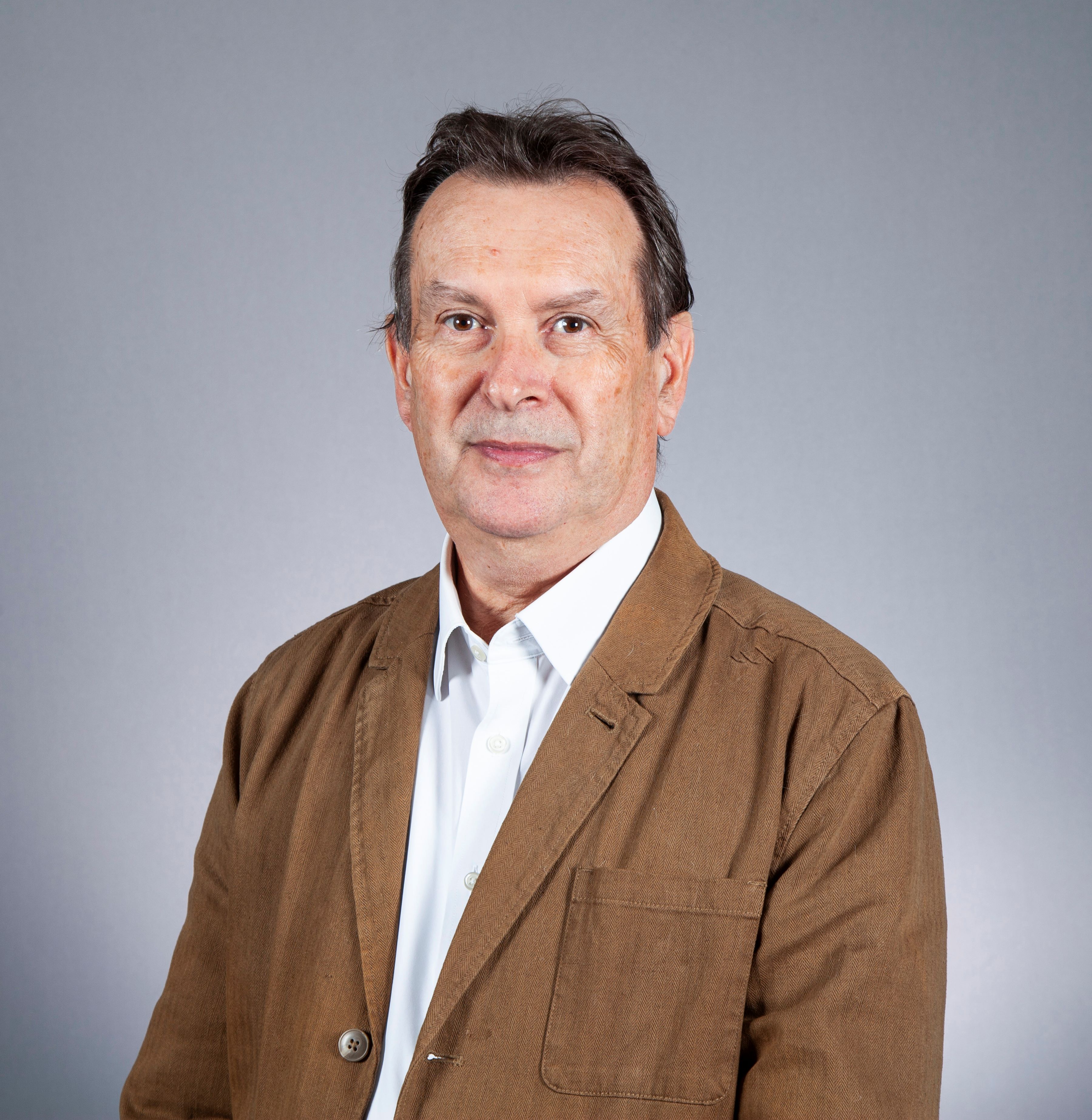 Person wearing white shirt and tan jacket