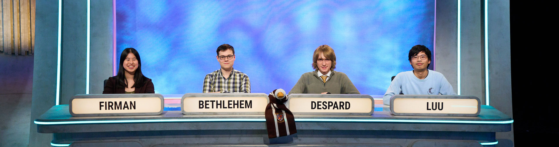Four people sitting in a row in a TV studio
