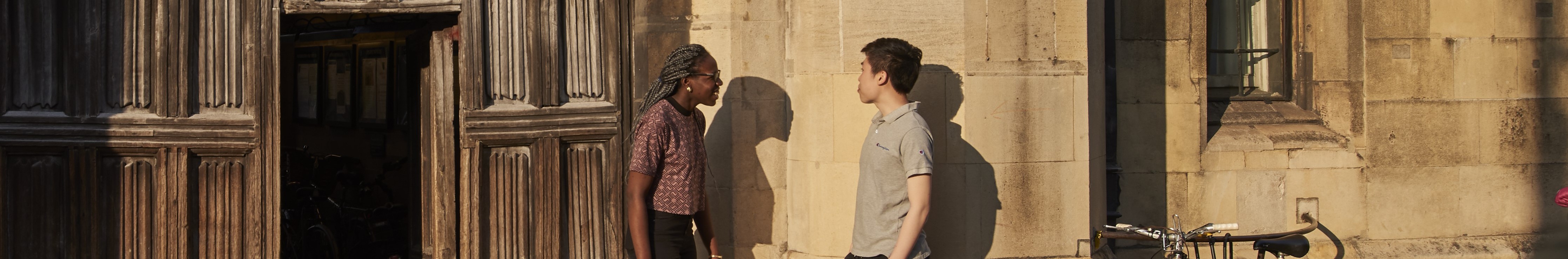 Two students talking by the main gate