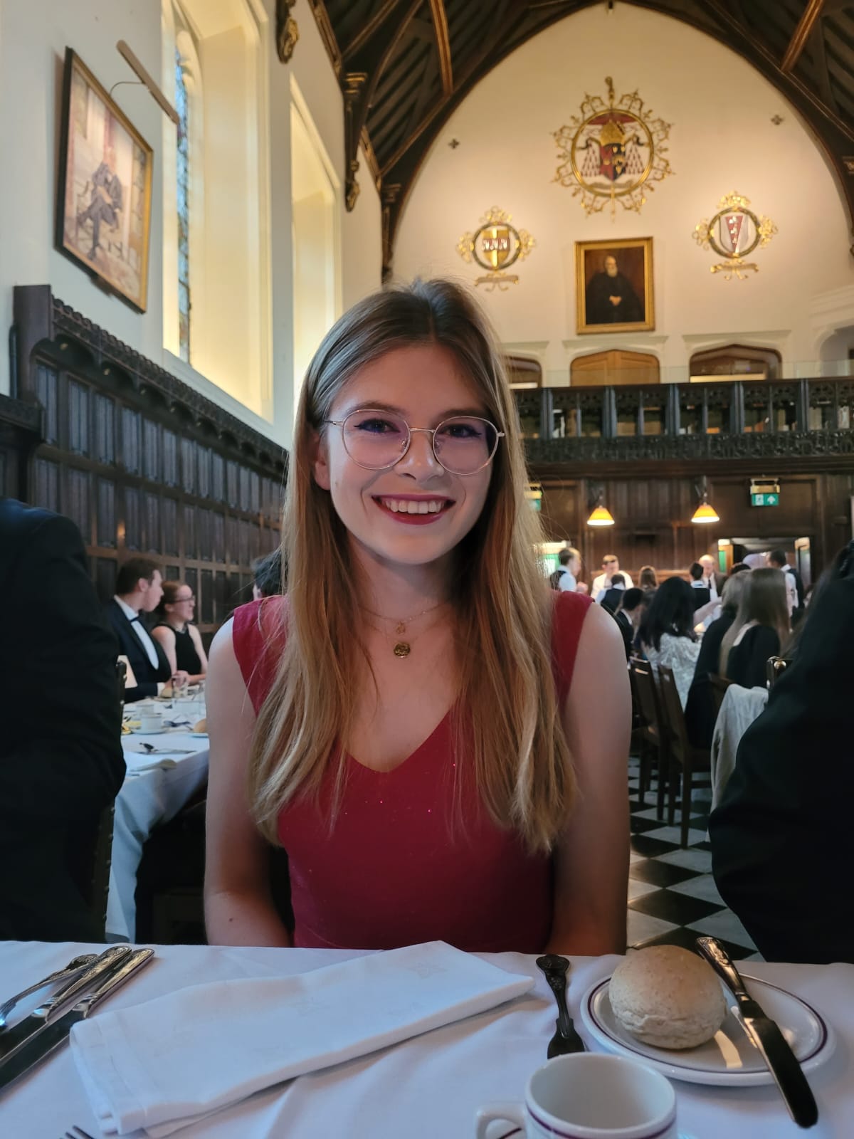 Oliwia sat in formal hall in a red dress