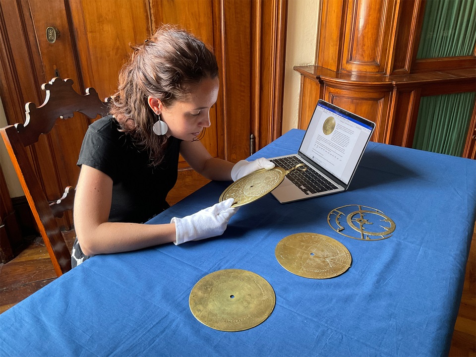 Person wearing gloves examining a brass instrument