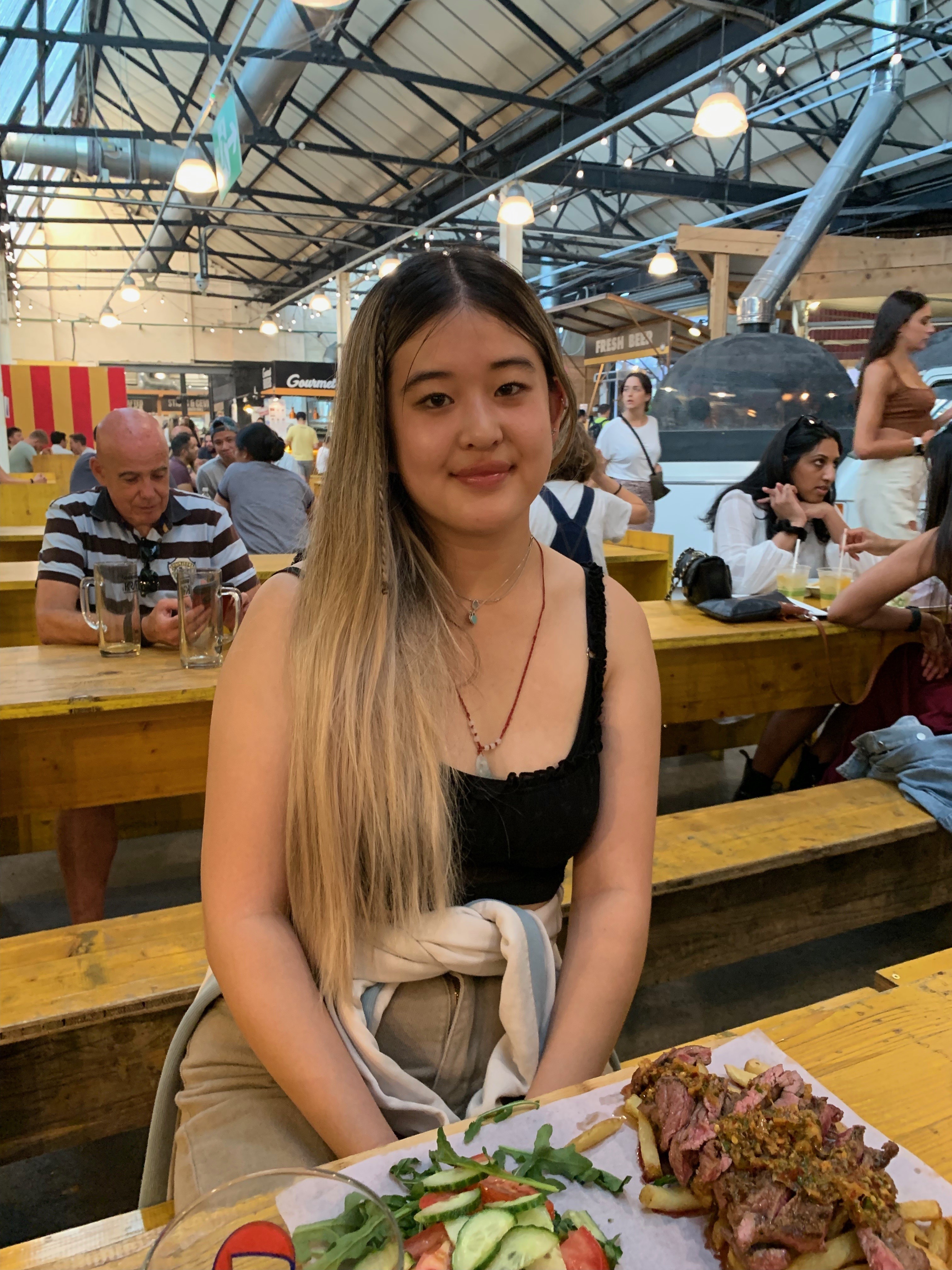 Hannah with a plate of food, sat in a cafe