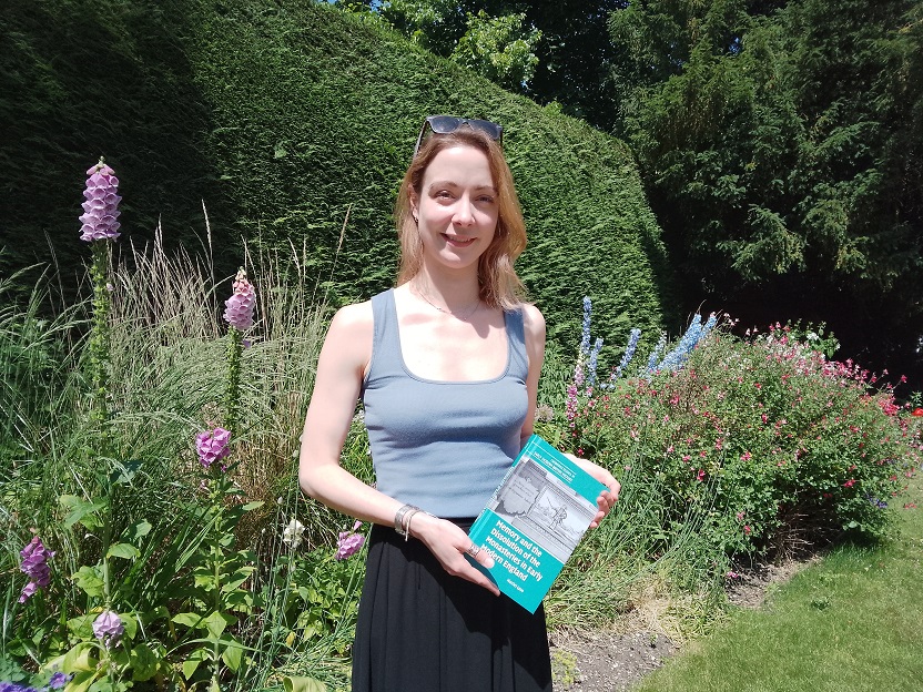 Harriet in garden holding her book