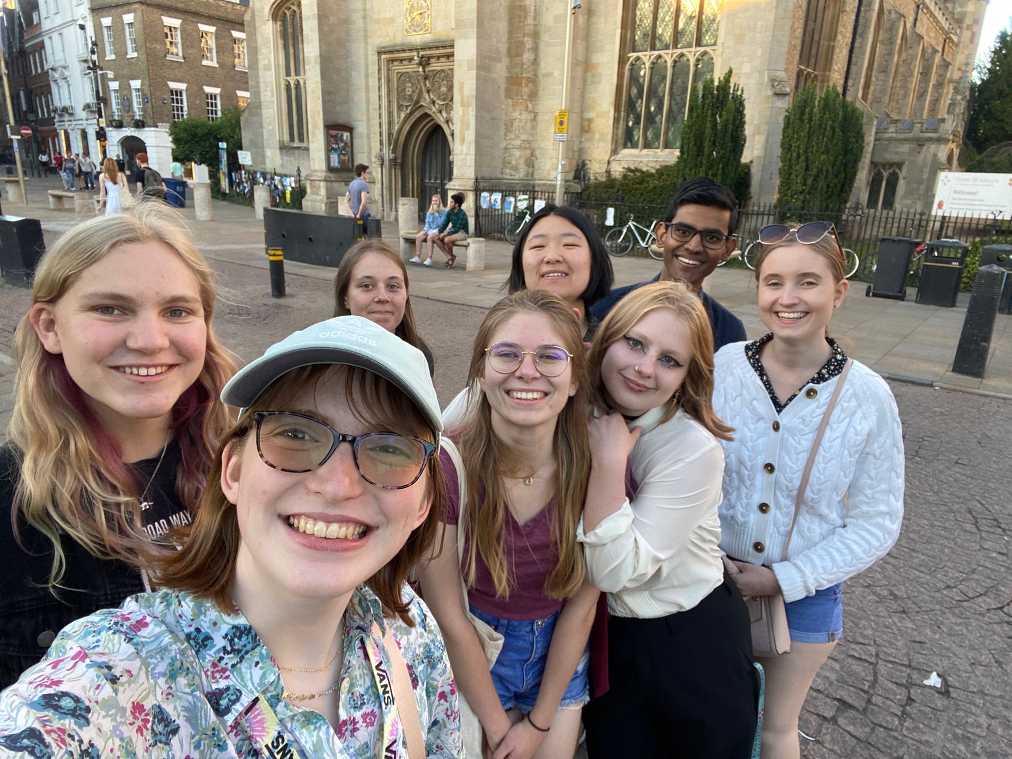 A selfie of eight students in front of a Cambridge church