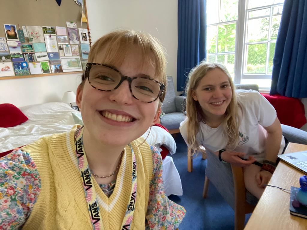 A selfie of two students studying in a bright room