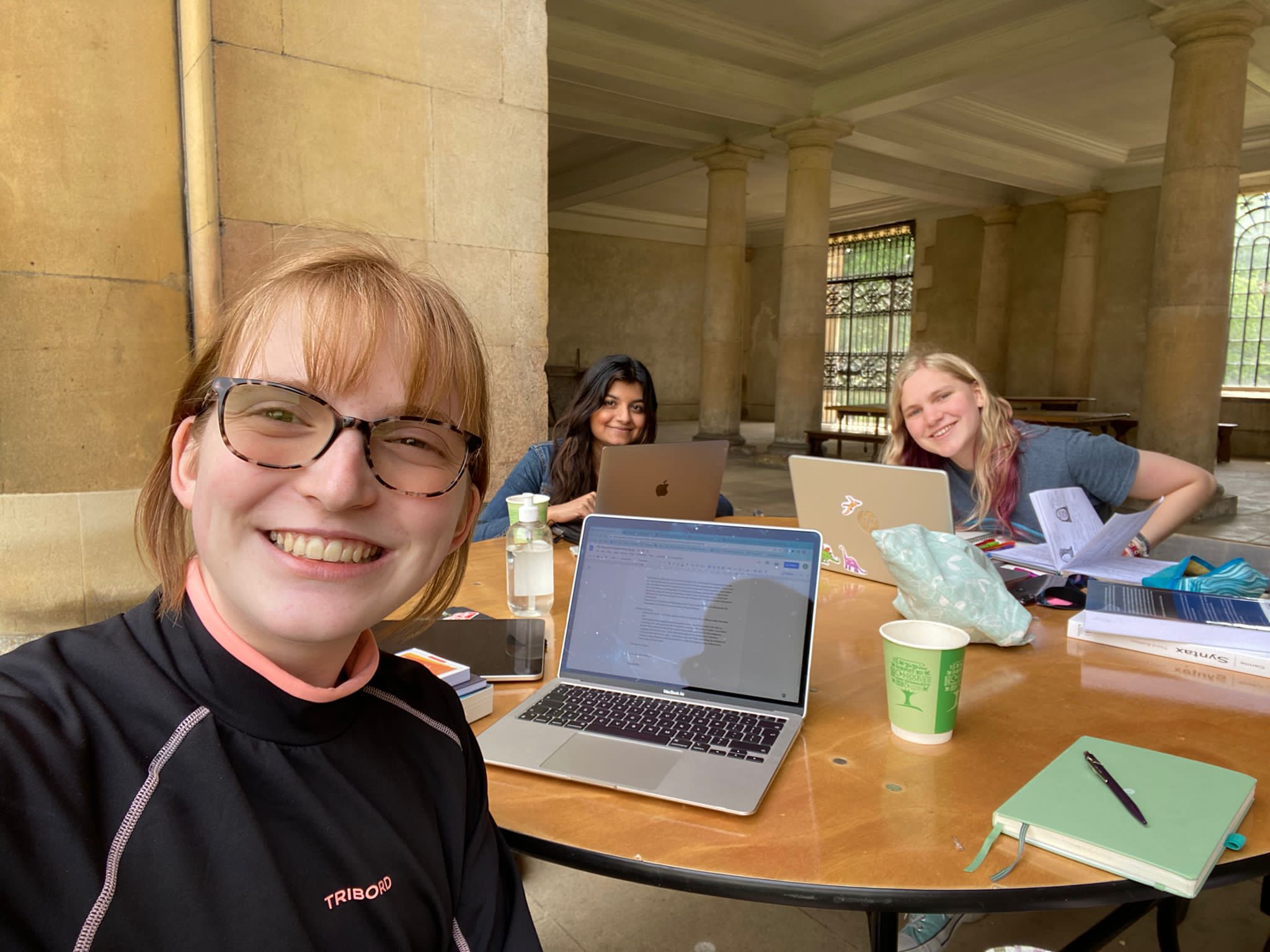 A selfie with three students at a desk, outdoors