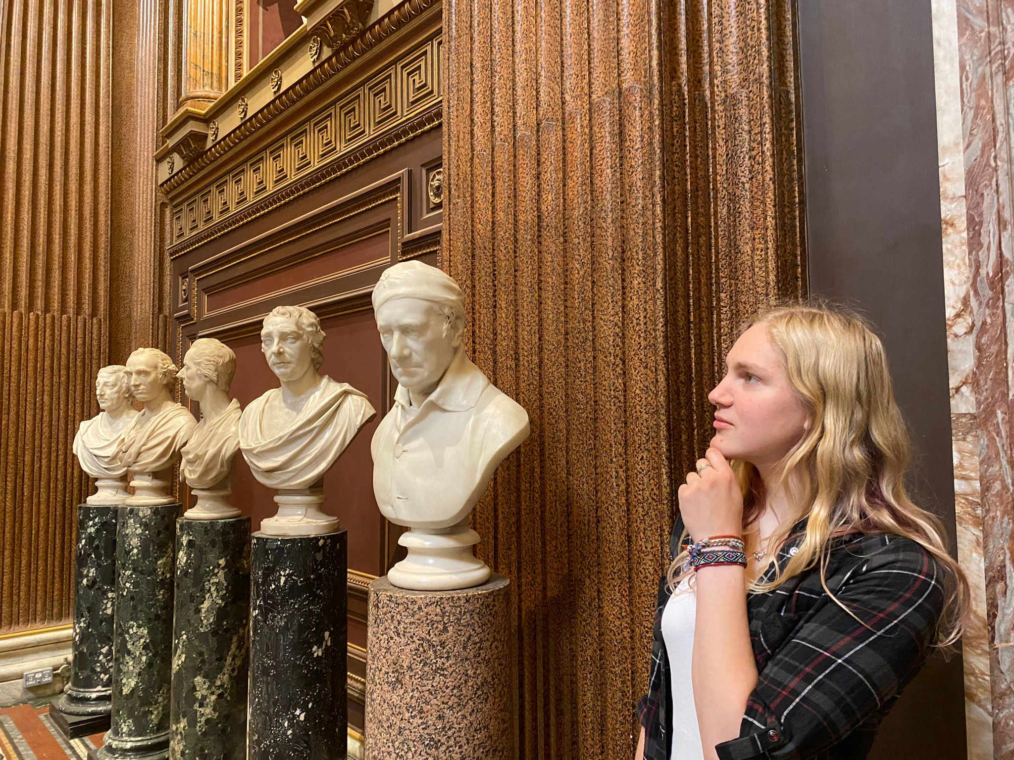 Romany posing like a statue in front of a line of statues