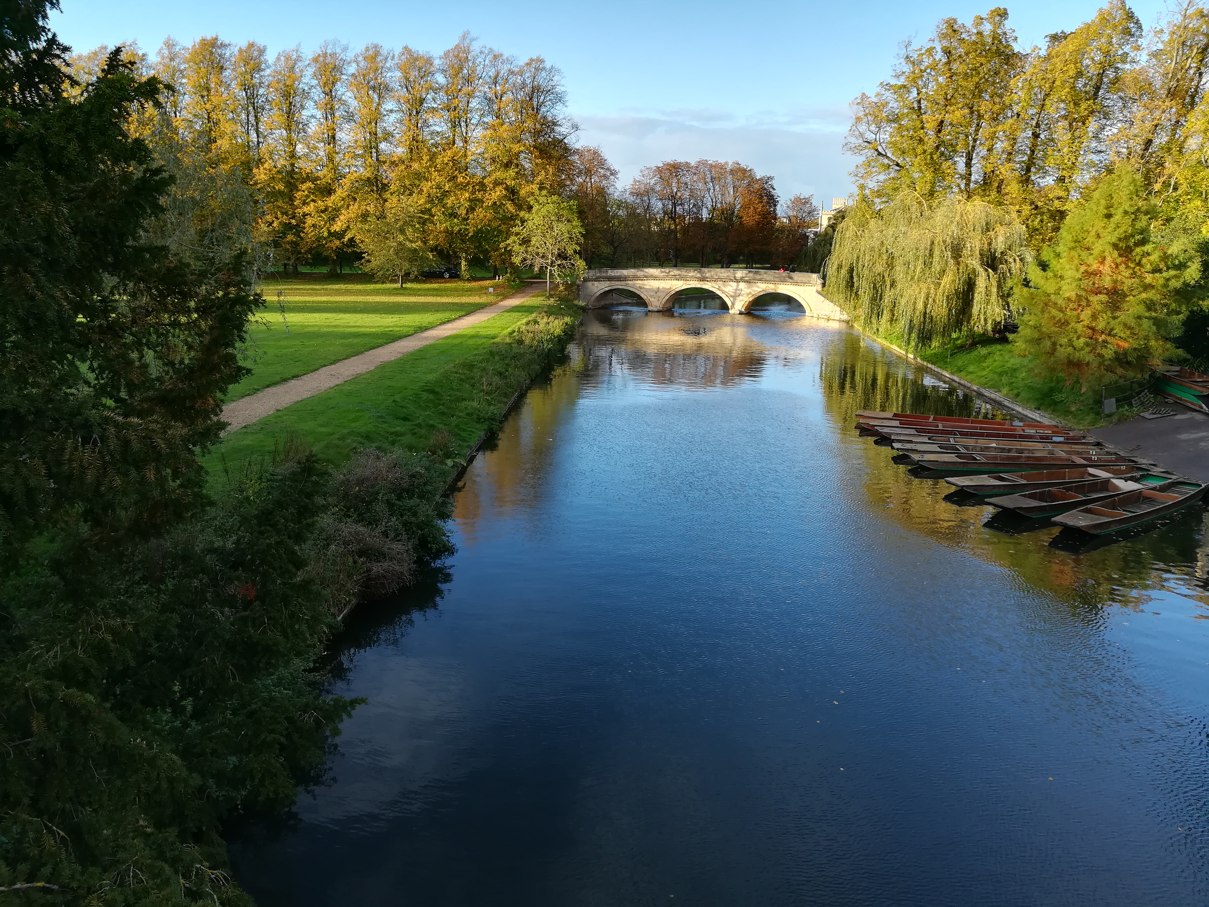 A bridge over calm water, with punting boats in the foreground