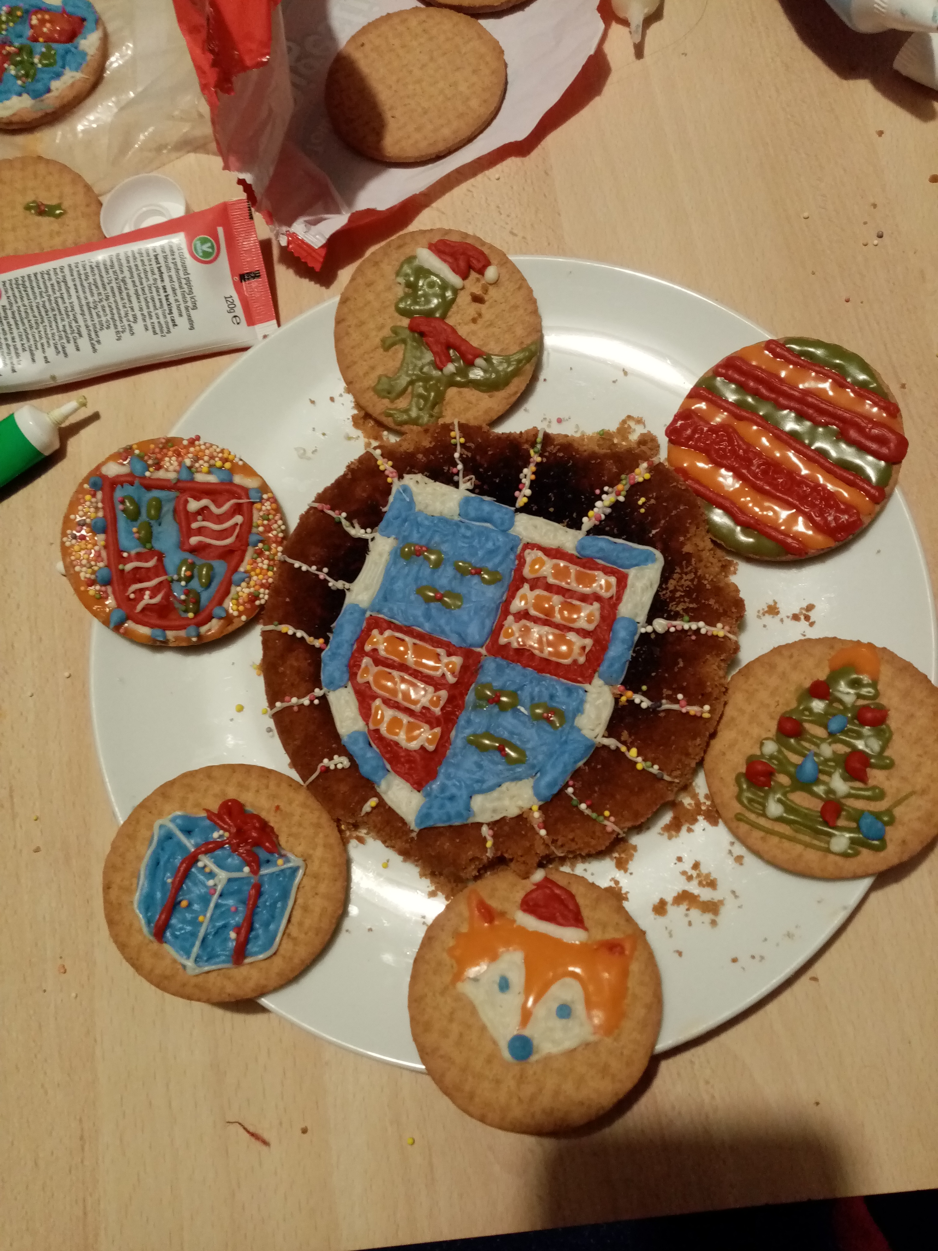 A plate of biscuits, decorated. One has a Christ's crest on it