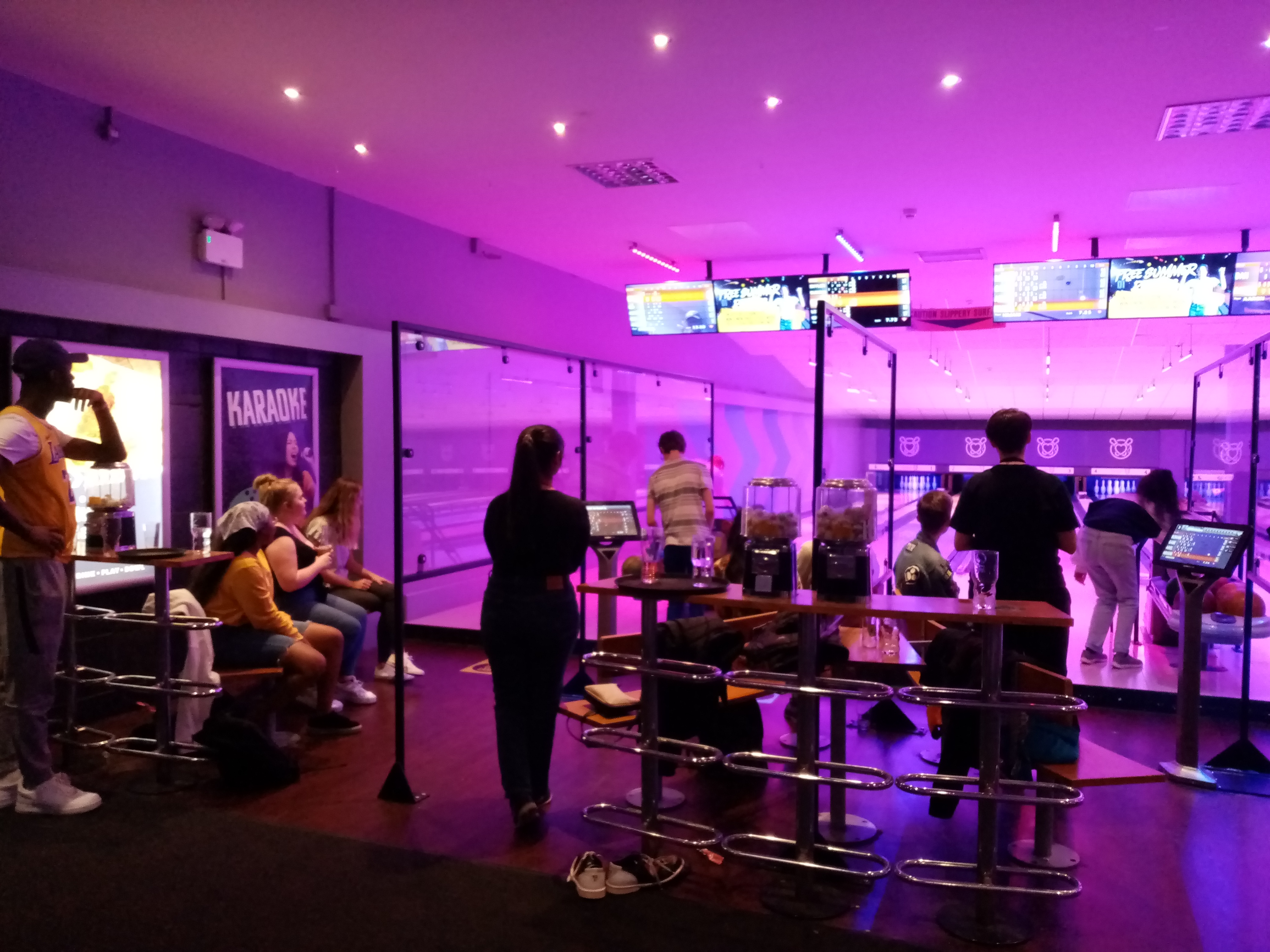 A bowling alley, with the lanes visible and the backs of several students, 