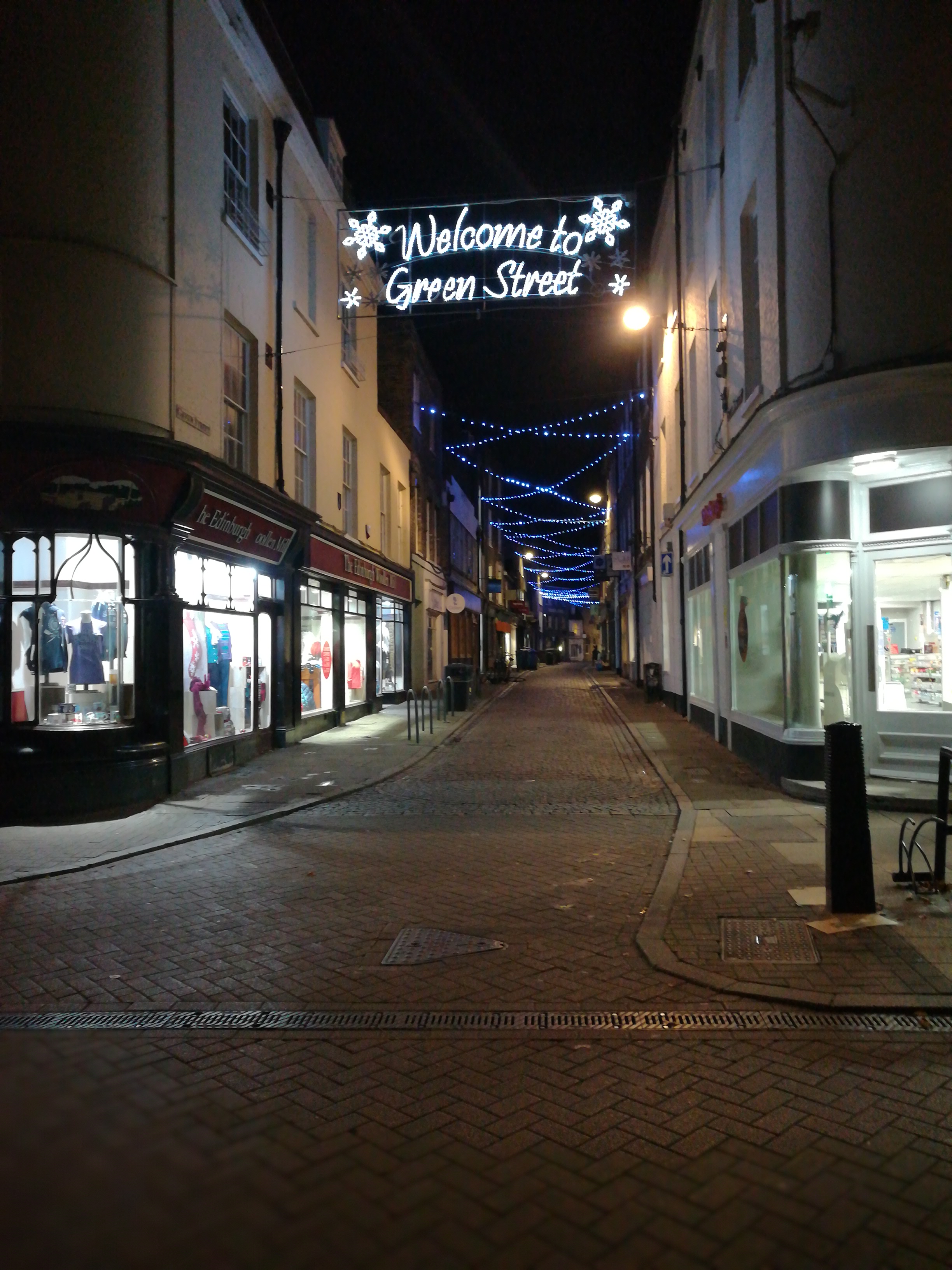 Lights spelling out "welcome to Green street", with shops either side.