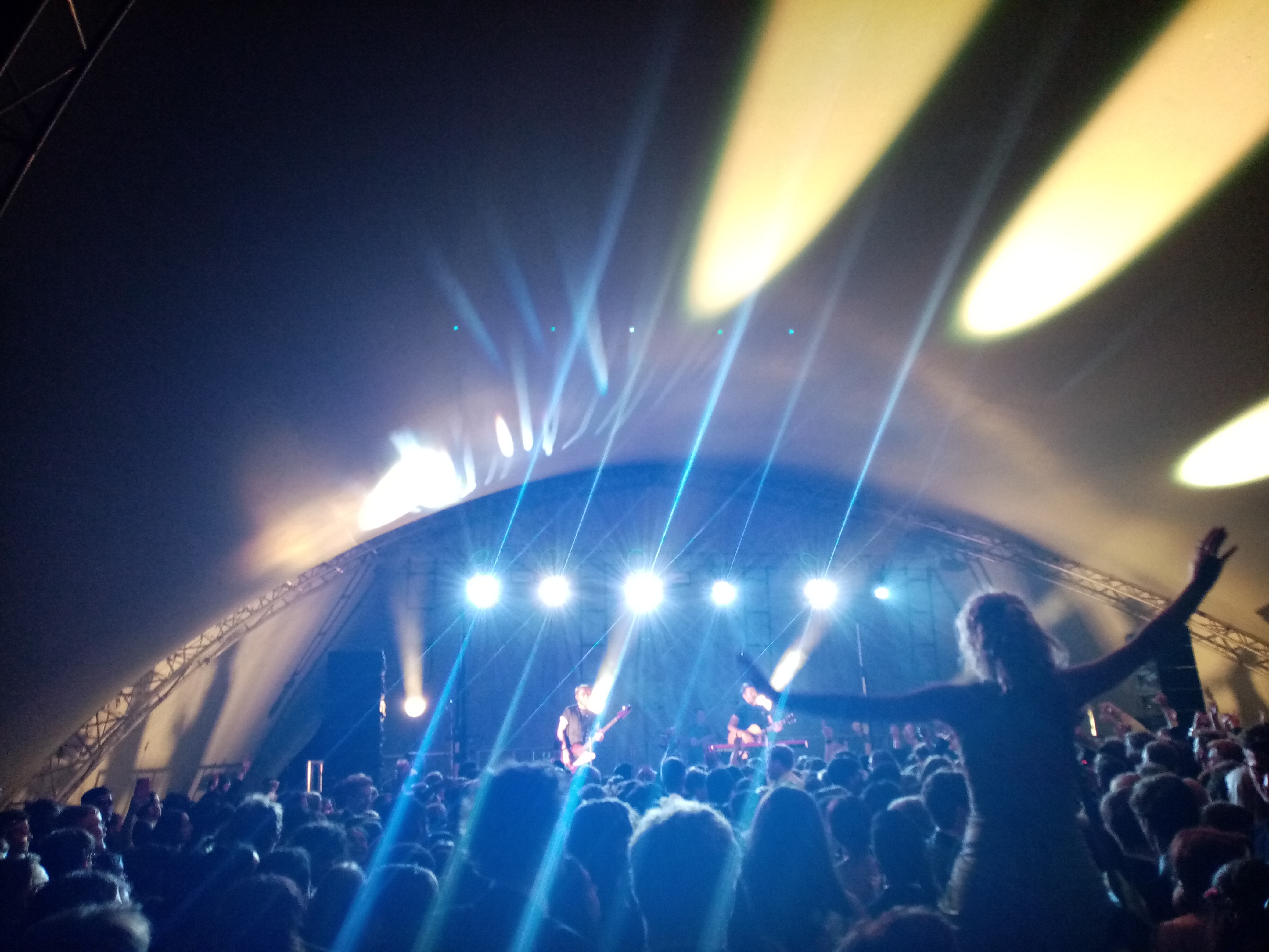 a large crowd dancing in front of a stage