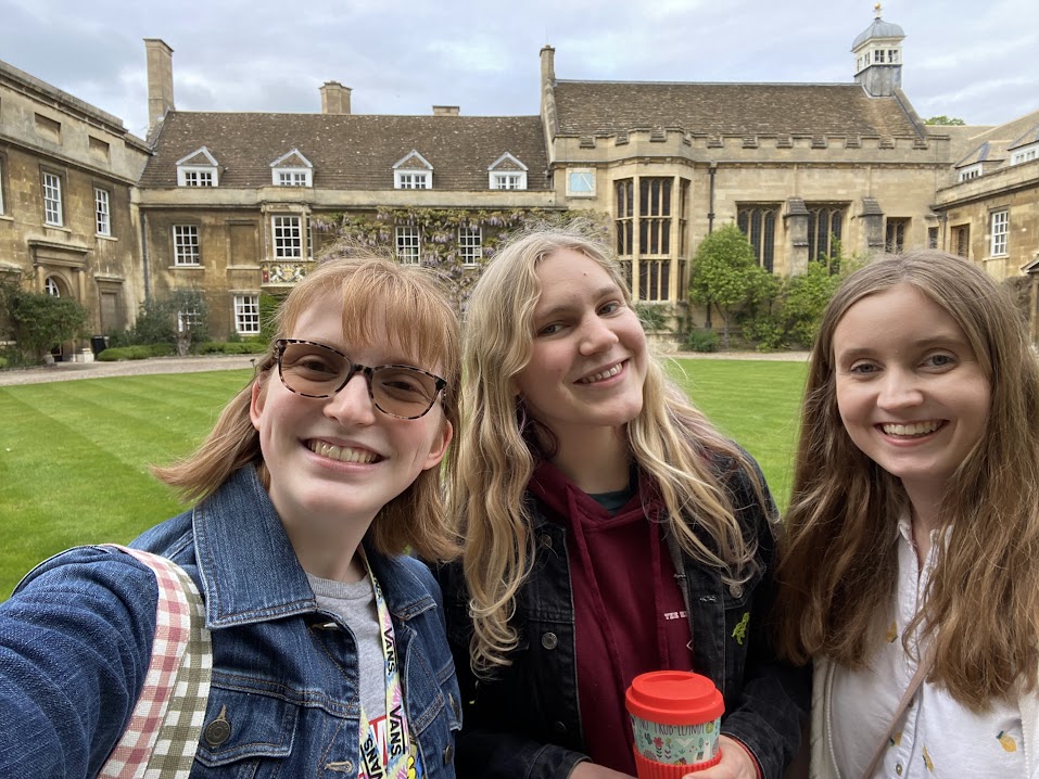 Three students, one holding a coffee cup, in first court