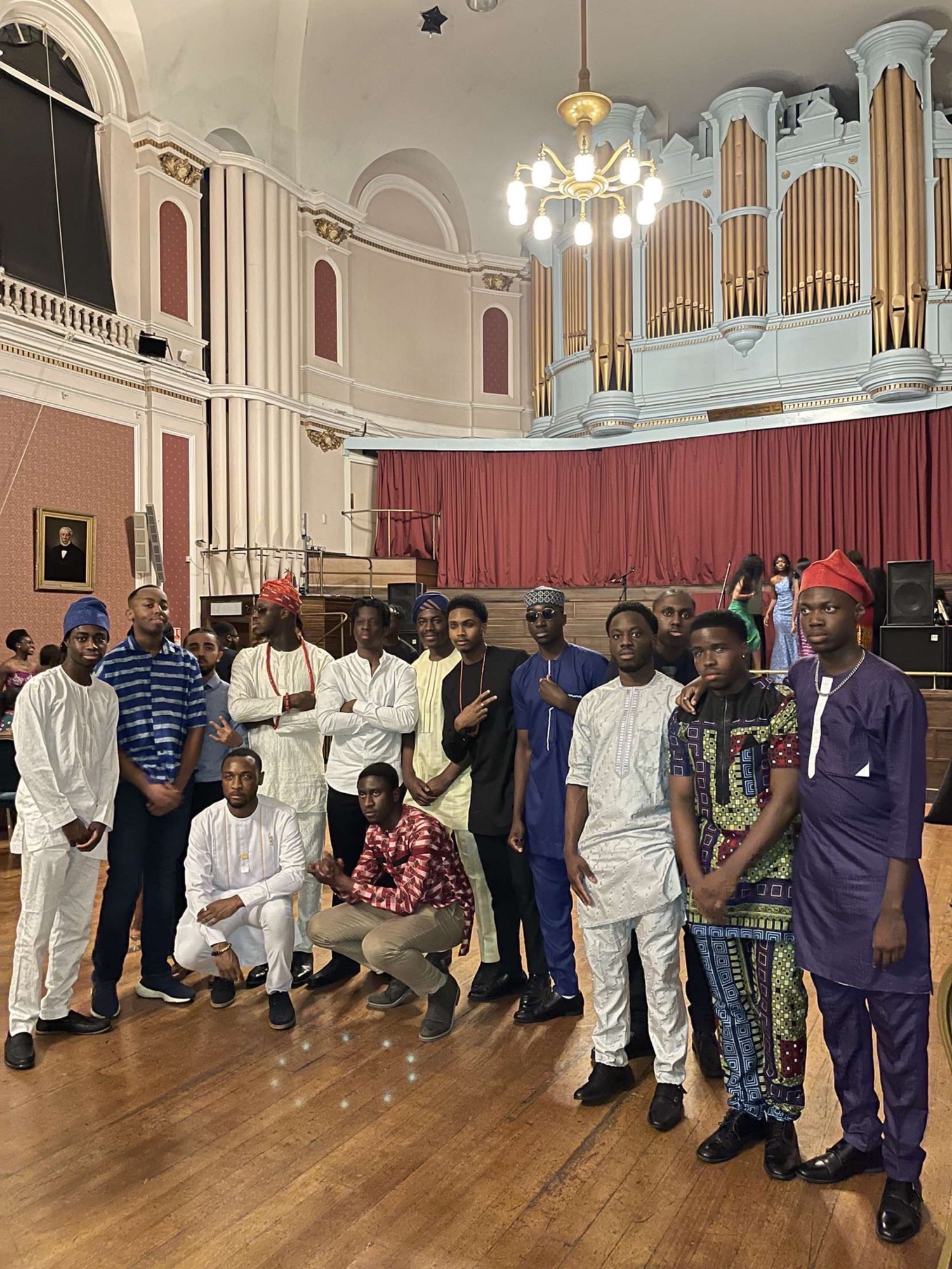 A group of friends in traditional African and Caribbean dress at an event