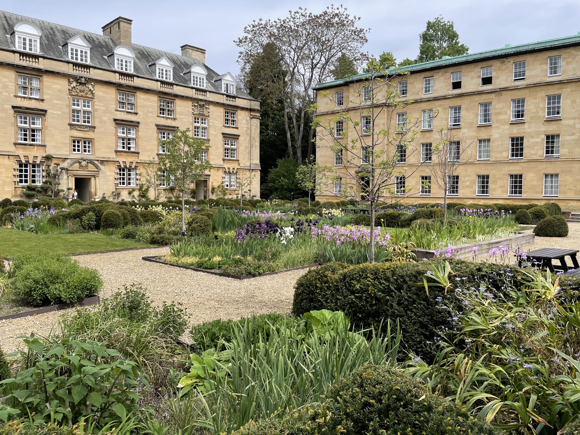 Third court, with flowerbeds in the foreground and old buildings in the background