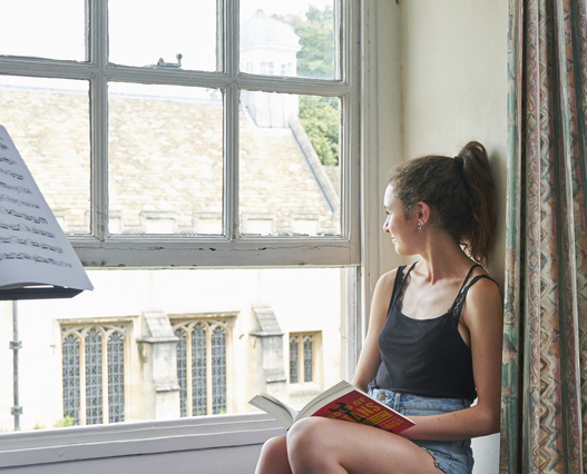 Student sat in the window with a book