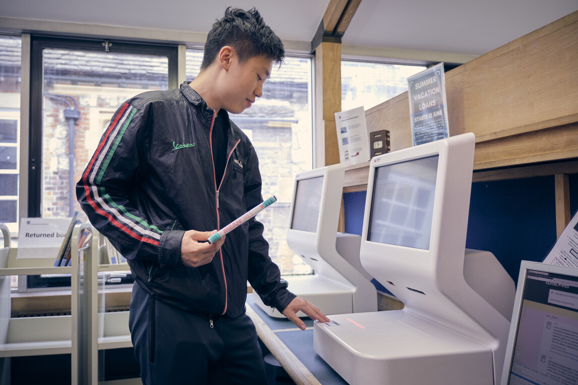 Oscar uring the self-service machines in the library