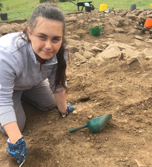 A student digging at an archaeological site