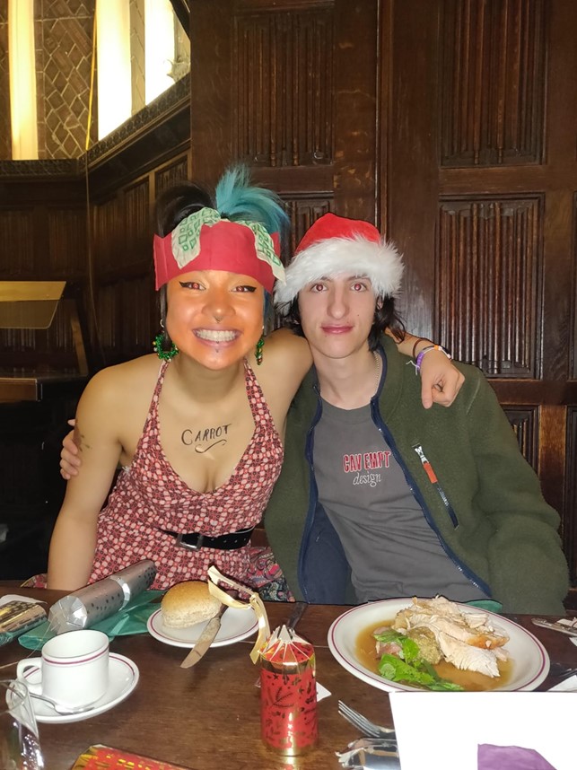 Two students in formal hall, wearing Christmassy headwear