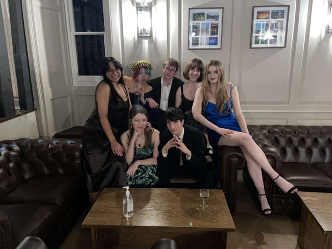 Group of friends sat on a sofa in the Buttery