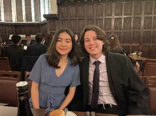 Two young adults, in formal hall, wearing formal dress