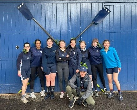 Crew group picture with oars at the Boathouse