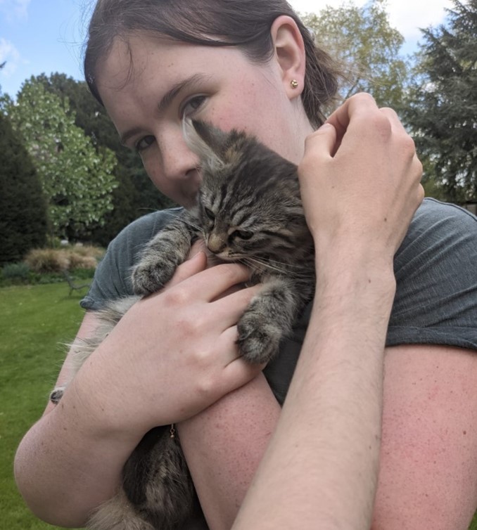 Annie cuddling a tabby kitten
