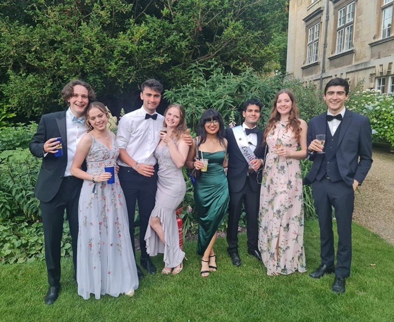 A group of friends in formal clothing, in the Fellows' garden at Christ's