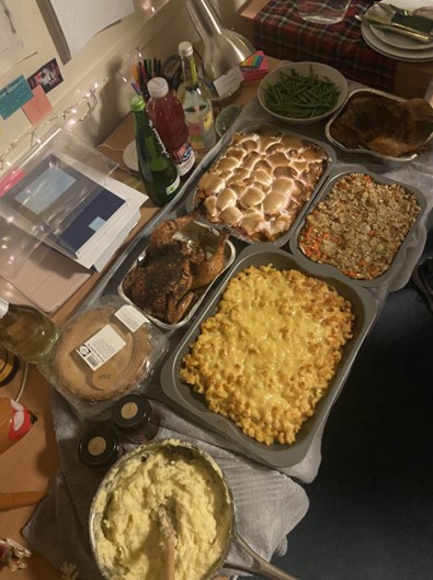 A table of delicious-looking food: mac and cheese, chicken, pie, mash, vegetables