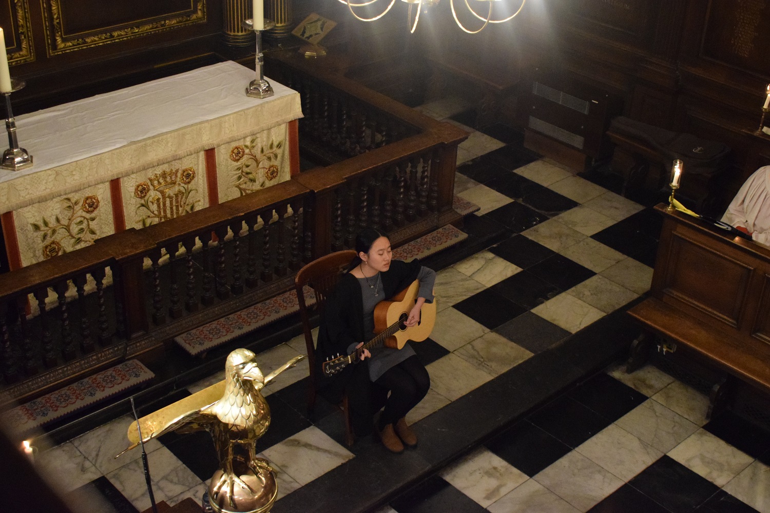A person playing the guitar in front of an altar