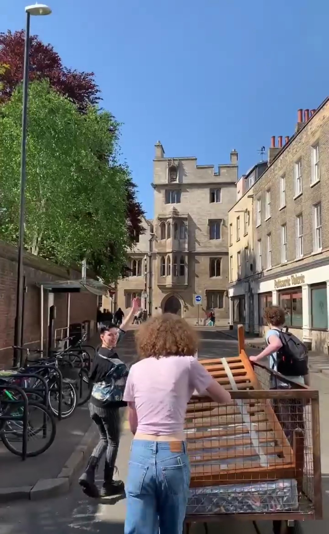 Three students moving theatre sets across cambridge