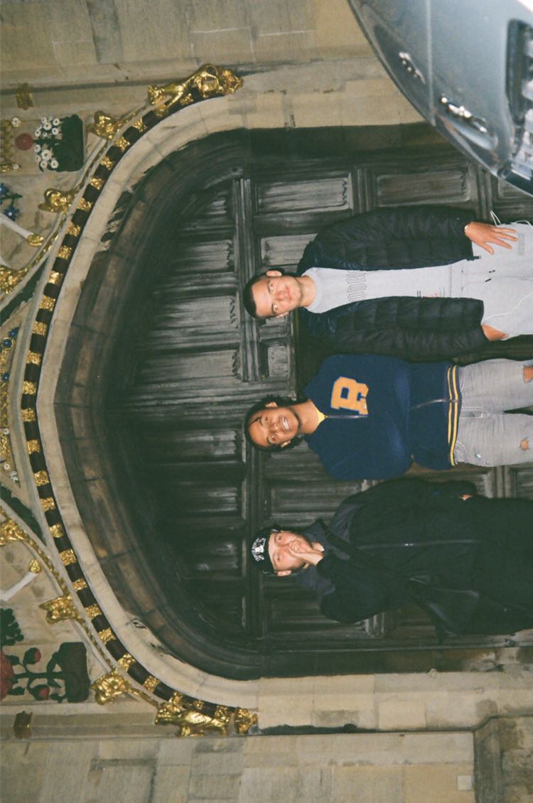 Three students stood in front of Christ's gate