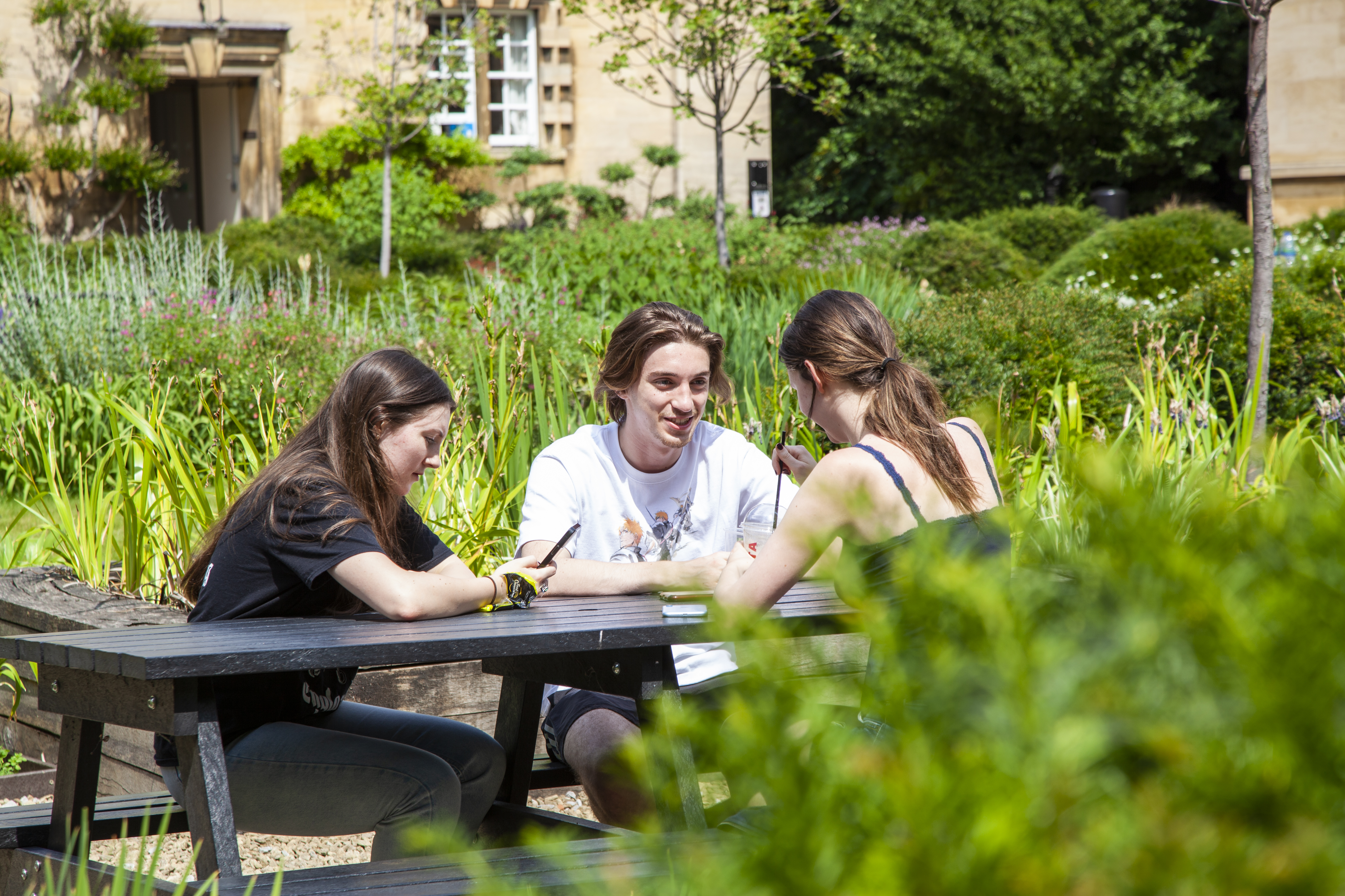 Three students at picnic table in Third Court