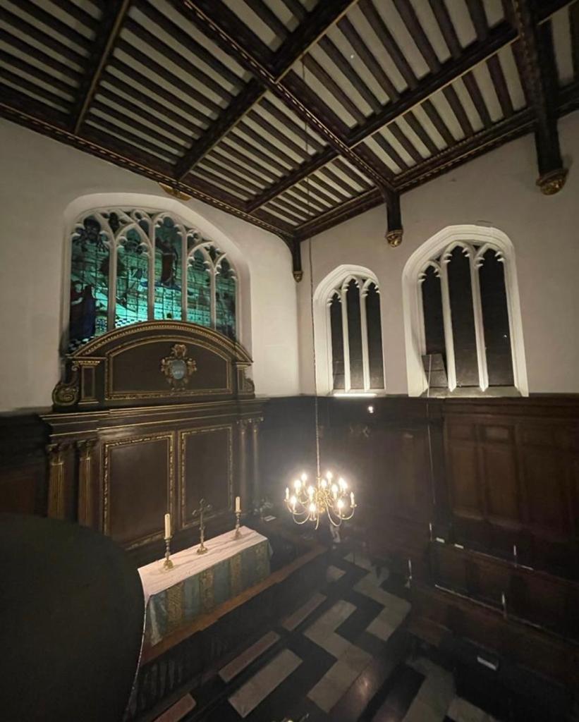 The chapel, with beams and candles and a big stained glass window.