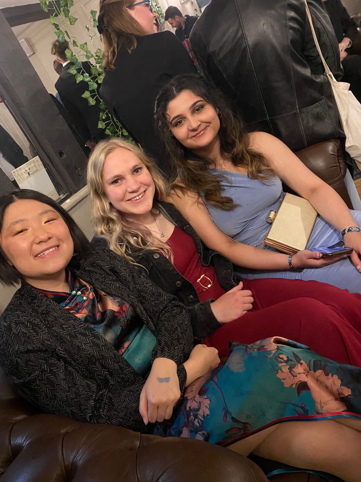 Three students in formal dress, sat down.