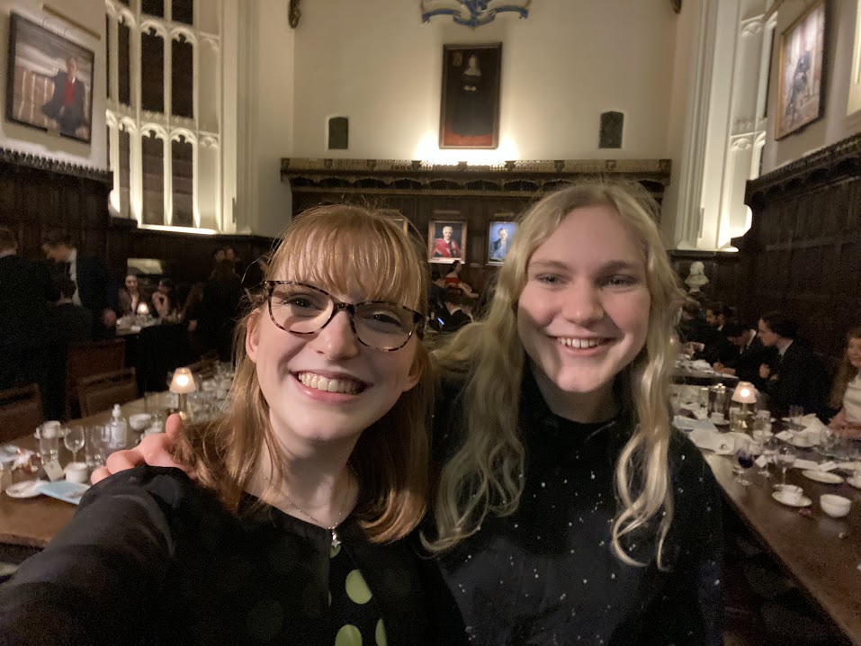 Two students in formal hall, laughing