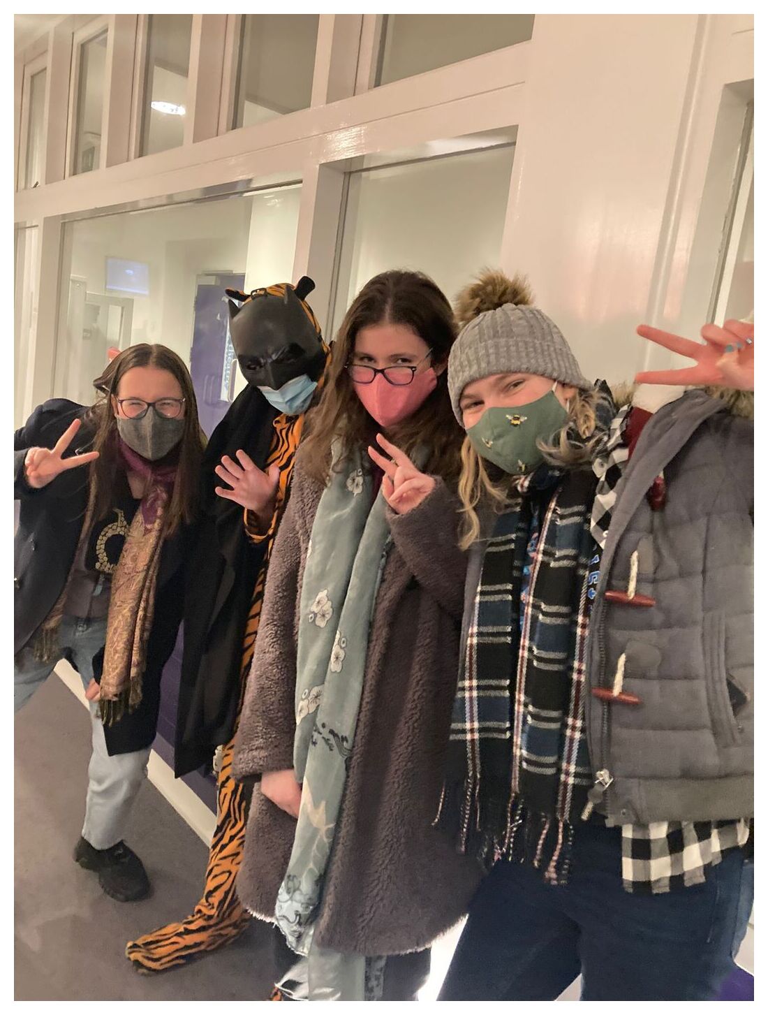 Four students with a person in a tiger onesie and a bat mask