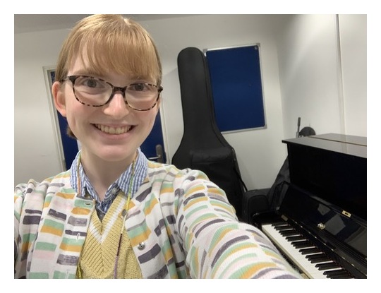 Selfie with a piano and guitar in the background