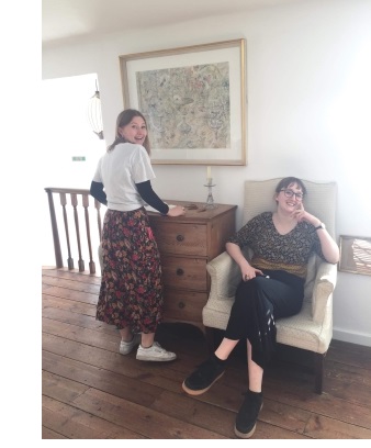 Two young women, one standing and one sitting on a chair, in the Kettle's Yard gallery in Cambridge.