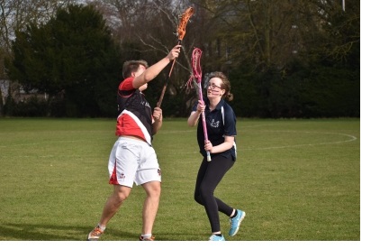 Two players, mid-game, at a mixed lacrosse cuppers match in Cambridge.