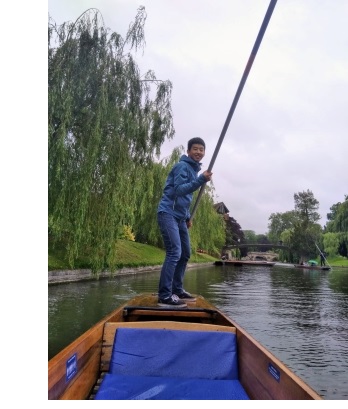 A young man steering a punt on the river Cam.