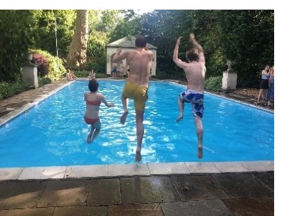 One woman (left) and two men (centre and right) jumping into a pool.