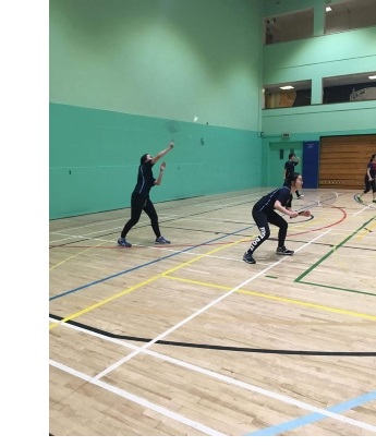 Badminton players in mid-match at the University Sports Centre in West Cambridge